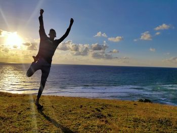 Full length of man at beach against sky during sunset