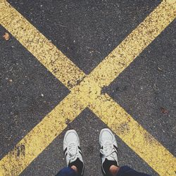 Low section of man standing on road