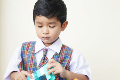 Close-up of boy looking away against white background