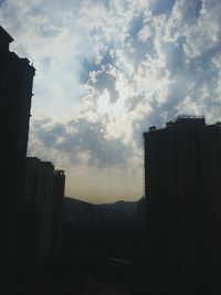 Buildings against cloudy sky at sunset