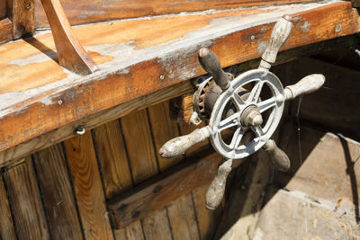 High angle view of rusty wheel on wooden wall