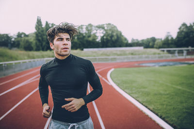 Young man running on track