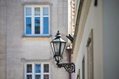 Illuminated street light against building