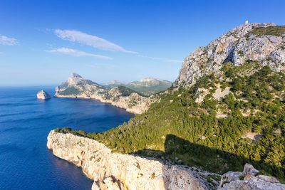 Scenic view of sea and rocks against blue sky