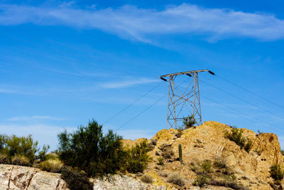 Low angle view of trees and mountains against blue sky