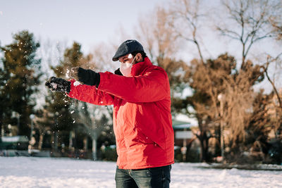 Full length of man standing on snow covered tree