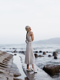 Rear view of woman standing at beach