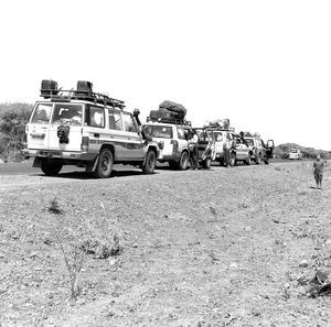 Cars on field against clear sky