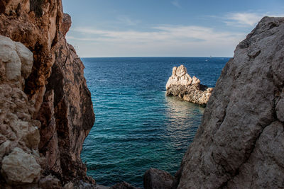 Scenic view of rocks in sea against sky