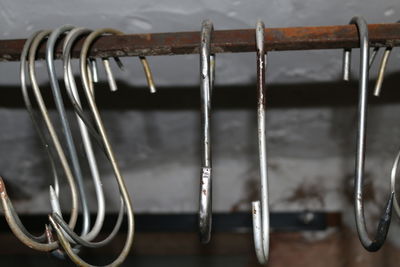 Close-up of hooks hanging on metallic rod