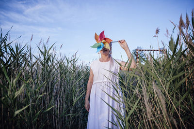 Girl with unrecognizable face holds windmill , wind energy