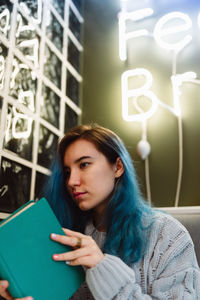 Young woman holding menu card at restaurant