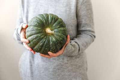 Midsection of woman holding pumpkin