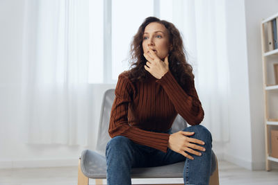 Portrait of young woman standing at home