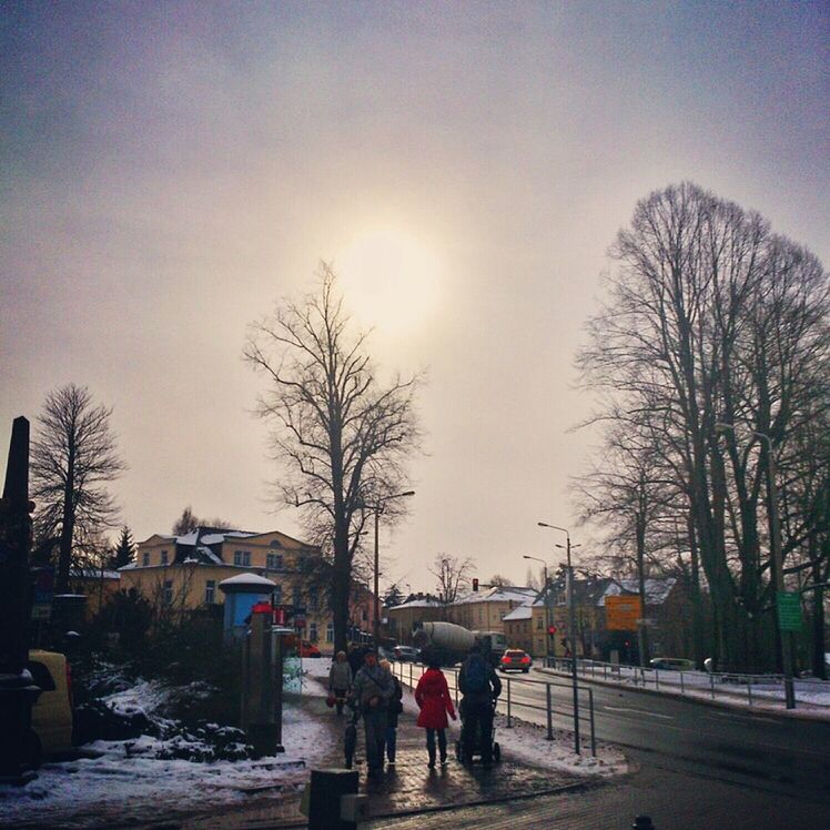 snow, winter, cold temperature, bare tree, season, tree, street, lifestyles, walking, building exterior, weather, men, full length, built structure, road, leisure activity, architecture, silhouette, clear sky