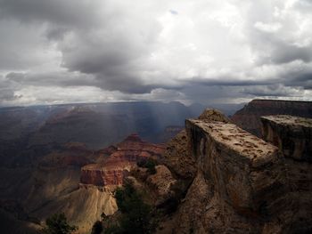 Rock formations at grand canyon against cloudy sky