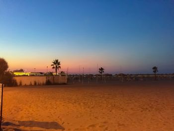 Scenic view of beach against clear sky during sunset