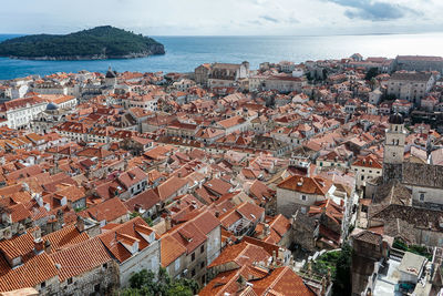 High angle view of townscape by sea against sky