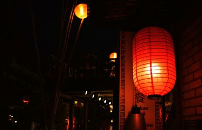 Low angle view of illuminated lanterns hanging at night