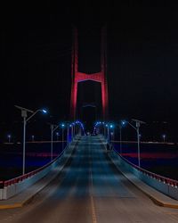 Light trails on road against sky at night