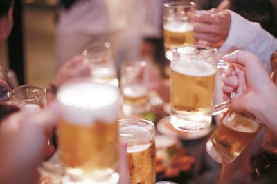 Cropped image of hands holding beer glasses