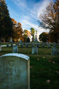 View of cross in cemetery against sky