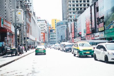 Traffic on road amidst buildings in city