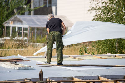 Rear view of man standing against built structure