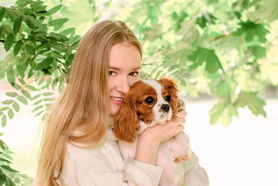 Portrait of beautiful woman with dog by tree