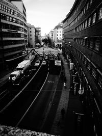 Cars on road in city against sky