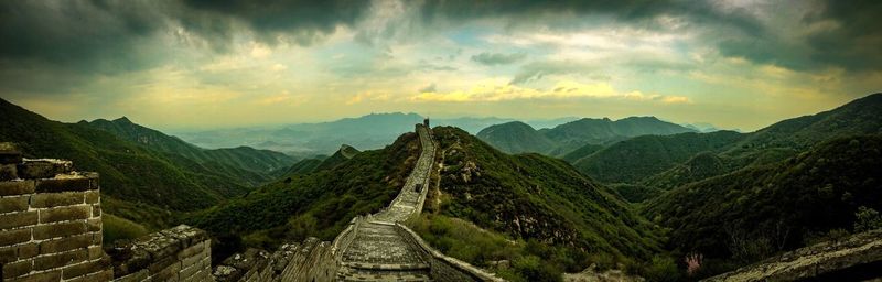 Scenic view of great wall of china and landscape against cloudy sky