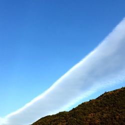 Low angle view of mountain against blue sky