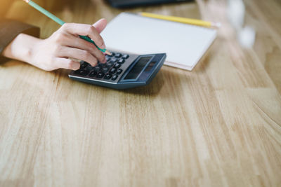 High angle view of woman using smart phone on table