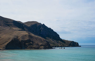 Scenic view of sea and mountains against sky