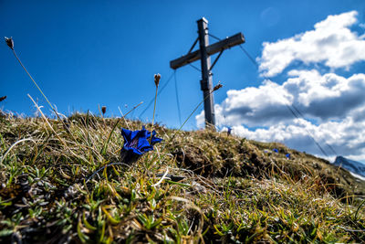 Surface level of cross on field against sky