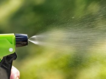 Cropped hand spraying water