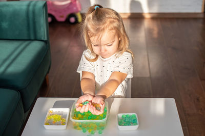 High angle view of girl sitting on table