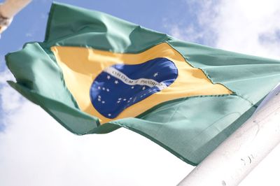 Low angle view of flag against blue sky