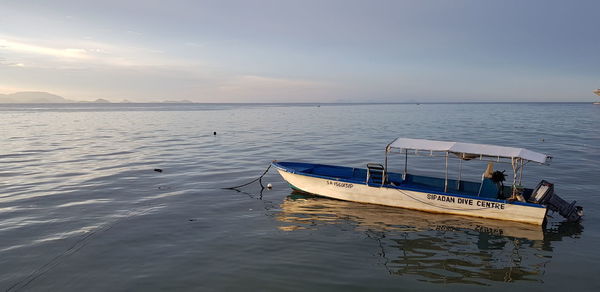 Boat moored in sea against sky