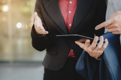 Midsection of man using mobile phone