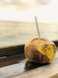 Close-up of coconut on table against sea