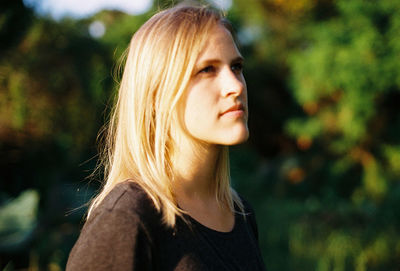 Portrait of young woman looking away outdoors