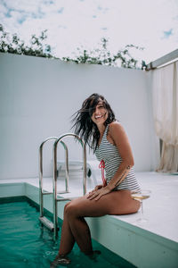 Woman sitting on swimming pool