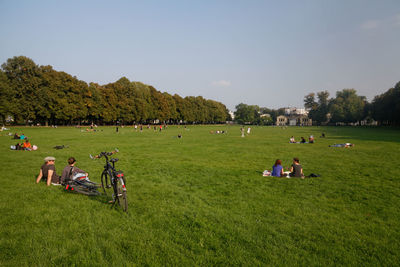 People relaxing on grassy field