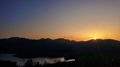 Scenic view of silhouette mountains against romantic sky at sunset