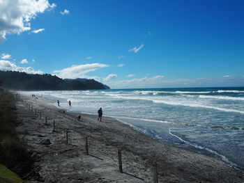 Scenic view of beach against blue sky