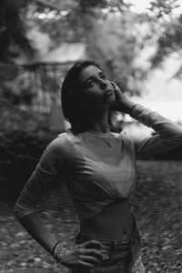 Thoughtful young woman looking away while sitting in forest