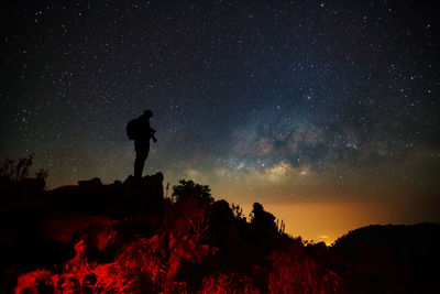 Silhouette of woman against star field at night