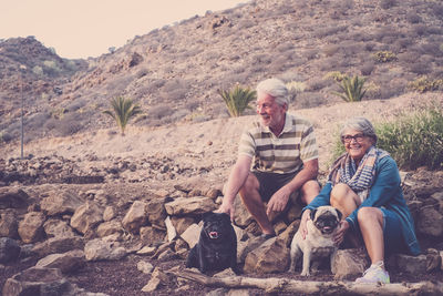 Senior couple with dogs on rocks