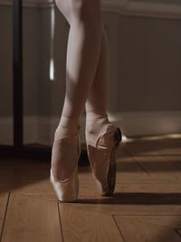 Low section of woman standing on hardwood floor